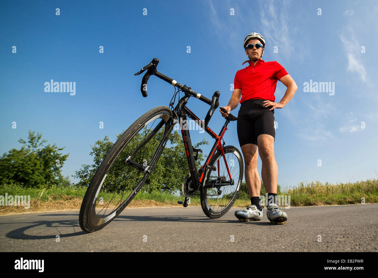 Ciclista, 44 anni, in piedi accanto ad un ciclo di corse, Winterbach, Baden-Württemberg, Germania Foto Stock
