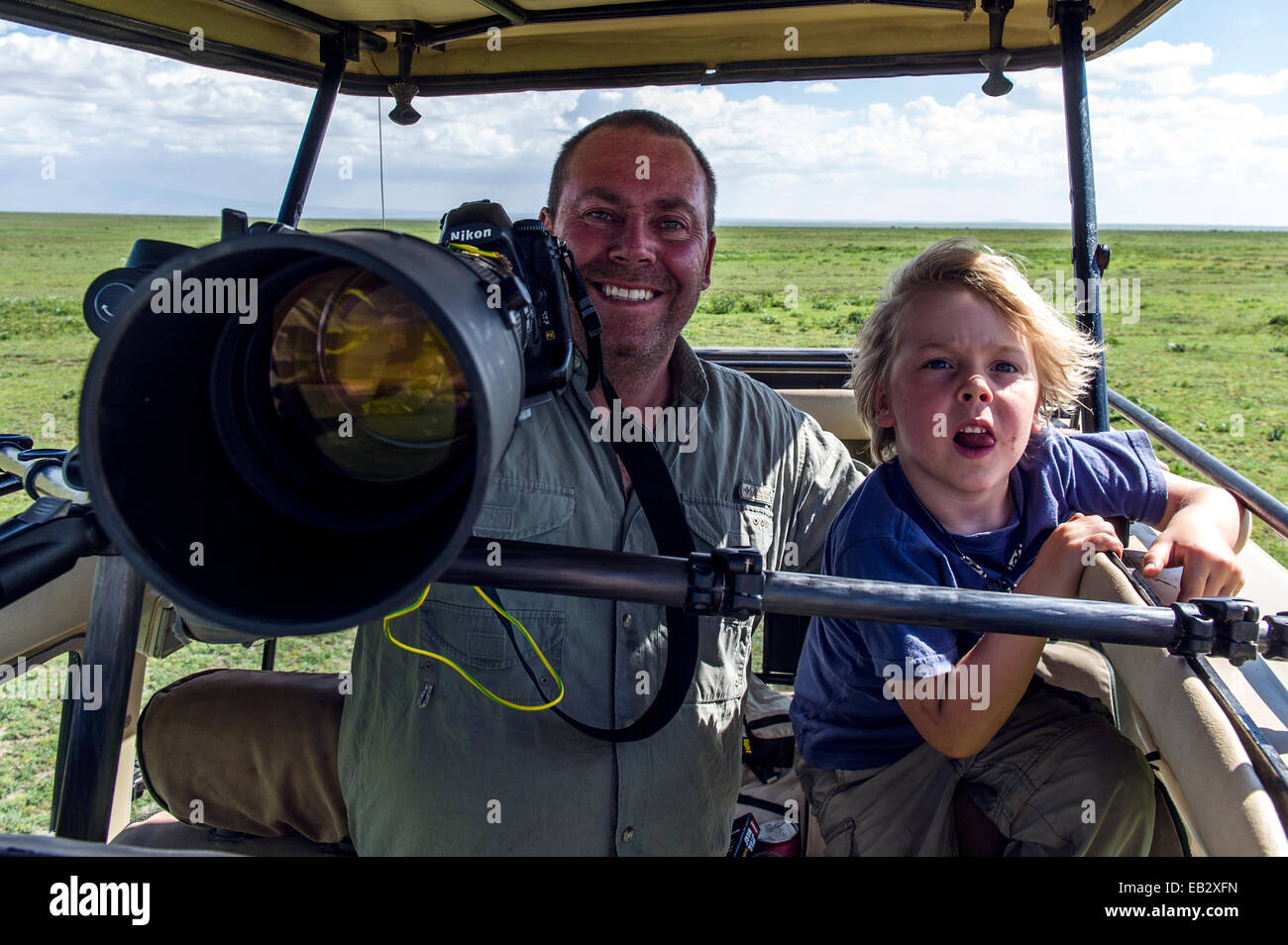 Un Wildlife Photographer e suo figlio con la loro fotocamera su safari su Savannah. Foto Stock