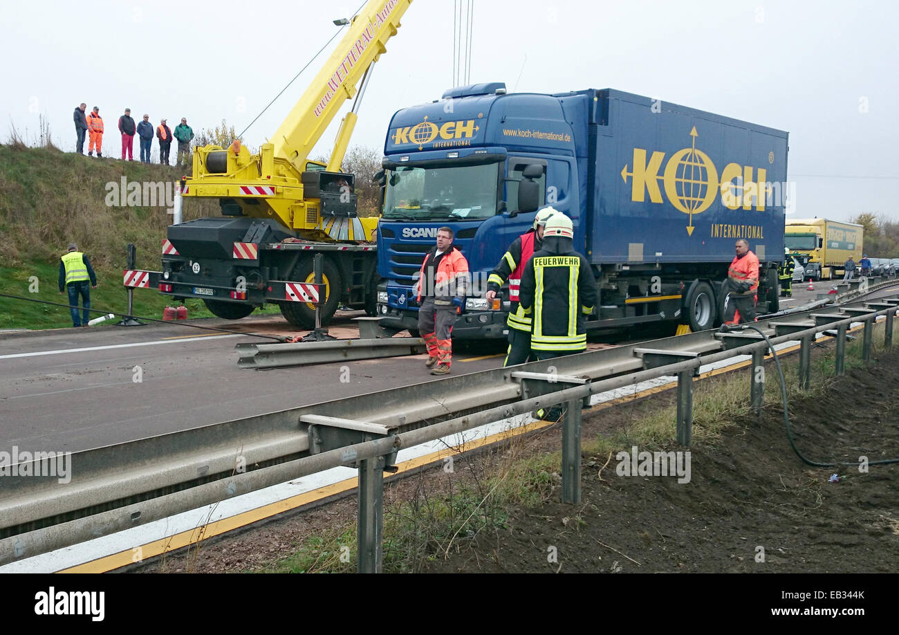 Bernburg, Germania. 25 Nov, 2014. Un rimorchio di un trattore è sollevato su Autobahn 14 vicino a Bernburg, Germania, 25 novembre 2014. Il carrello jack-knifed dovuta alla carreggiata sdrucciolevole e bloccato le altre corsie. Foto: Matthias Strauss/dpa/Alamy Live News Foto Stock