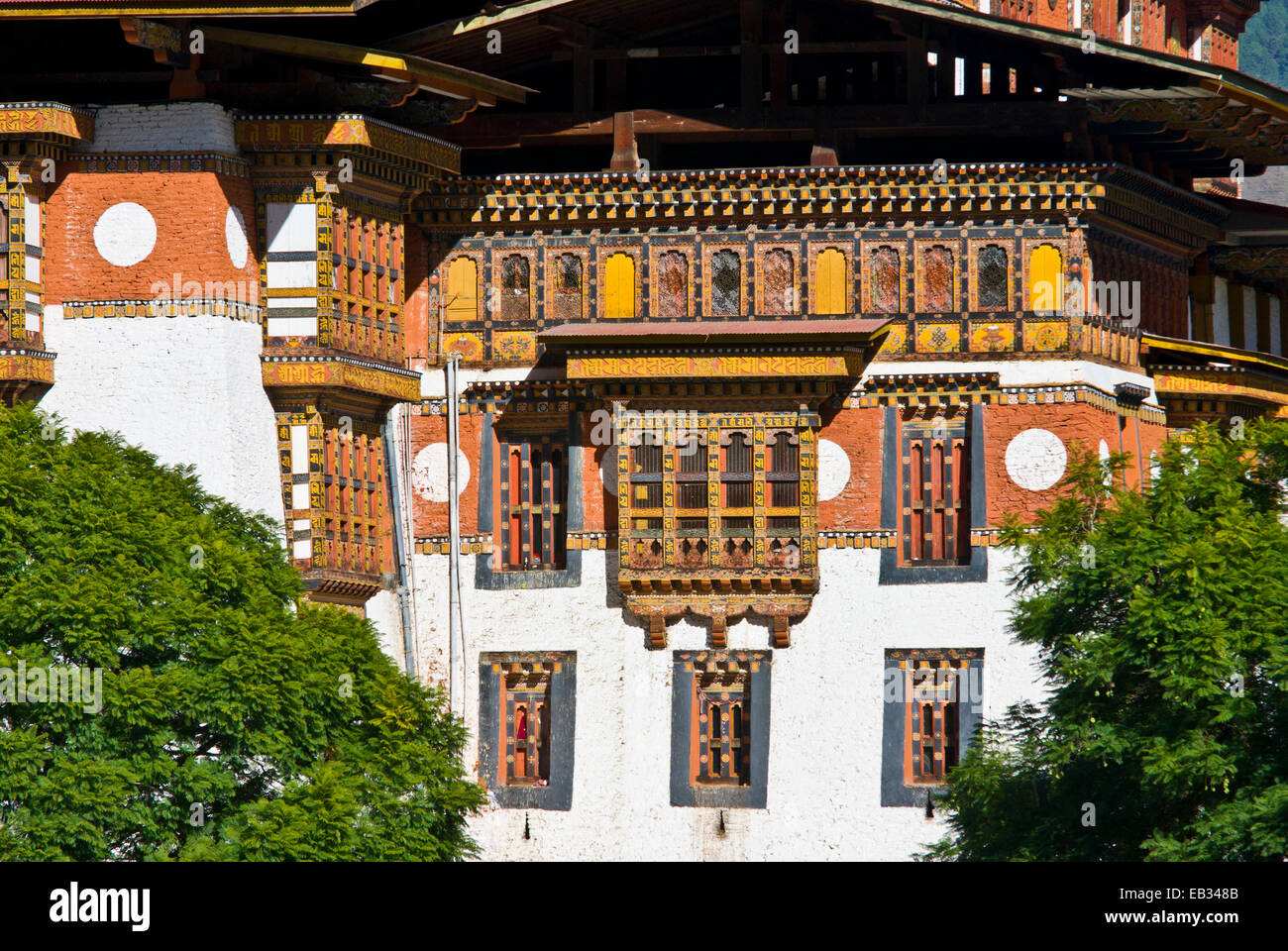 Riccamente intagliato e dipinto di telai di finestre e balconi su un antico monastero buddista di facciata. Foto Stock