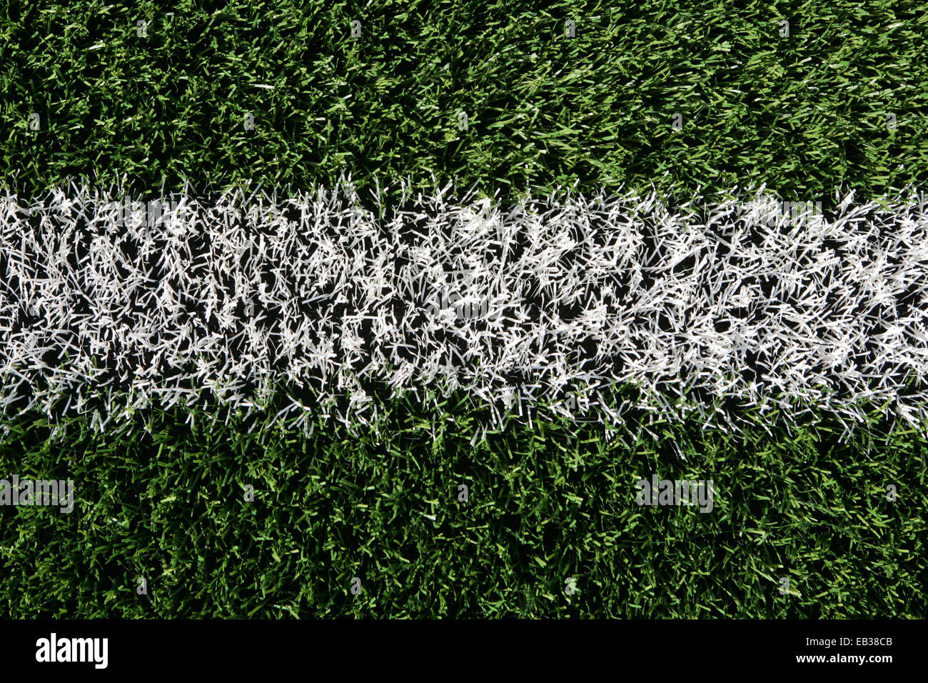 Close up di erba artificiale su una formazione di rugby di campo con una linea bianca. Foto Stock