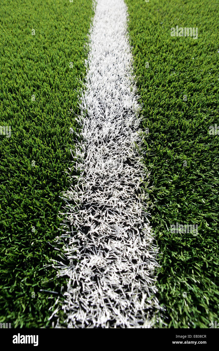Close up di erba artificiale su una formazione di rugby di campo con una linea bianca. Foto Stock