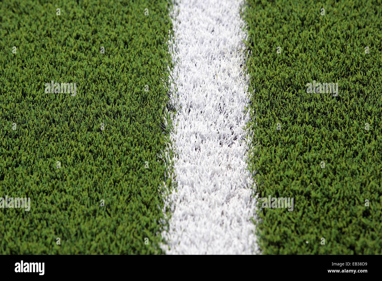 Close up di erba artificiale su una formazione di rugby di campo con una linea bianca. Foto Stock
