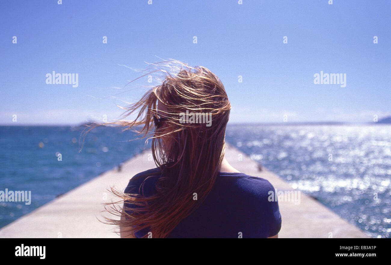Francia, Juan les Pins, vista posteriore della donna con il vento che soffia Foto Stock