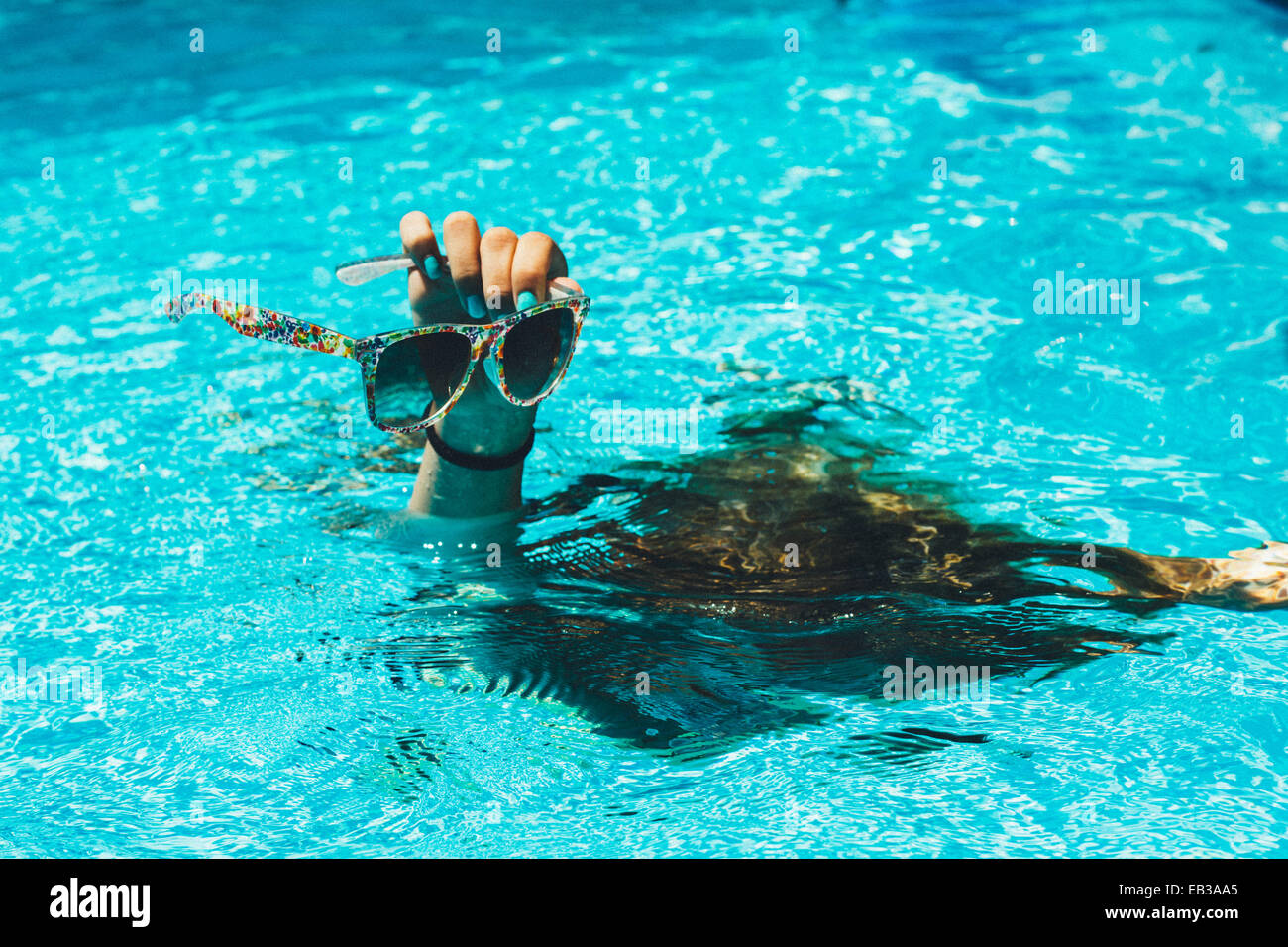 Mano con occhiali da sole spuntavano di acqua Foto Stock