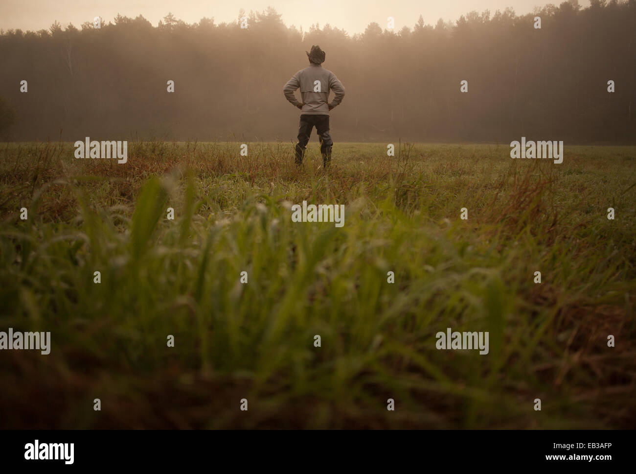 Razza mista man standing in campo nel paesaggio rurale Foto Stock