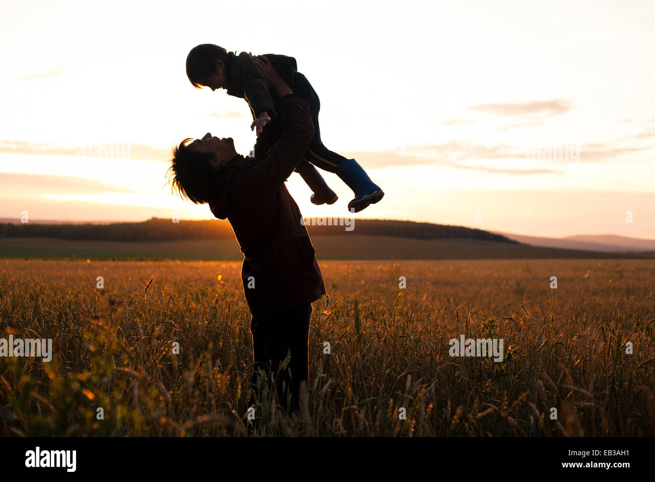 Mari padre e figlio giocando in campo rurale Foto Stock
