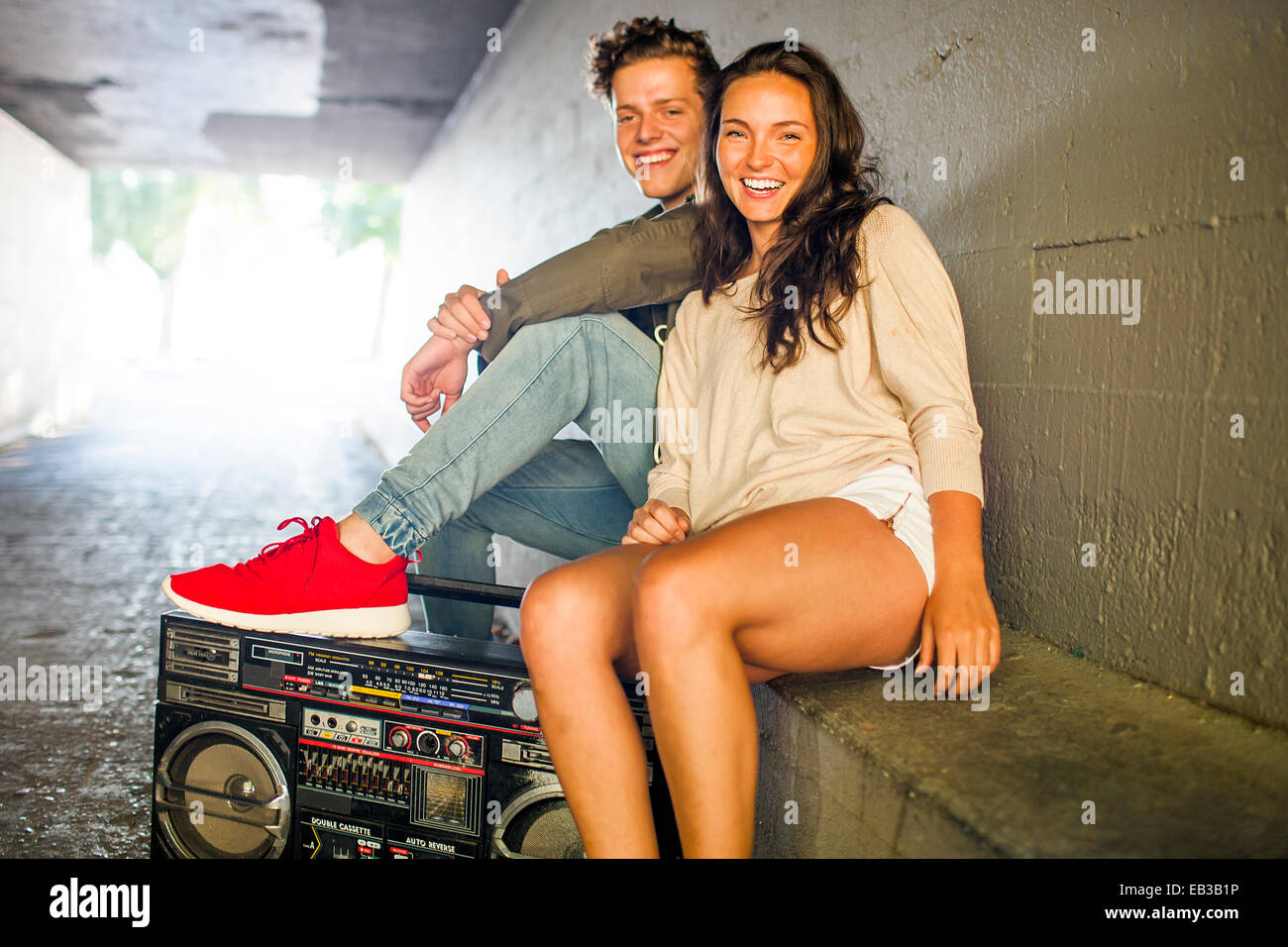 Coppia caucasica ascolto boom box nel tunnel Foto Stock
