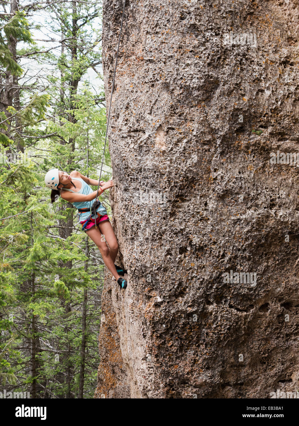 Razza mista ragazza salendo ripida scogliera Foto Stock