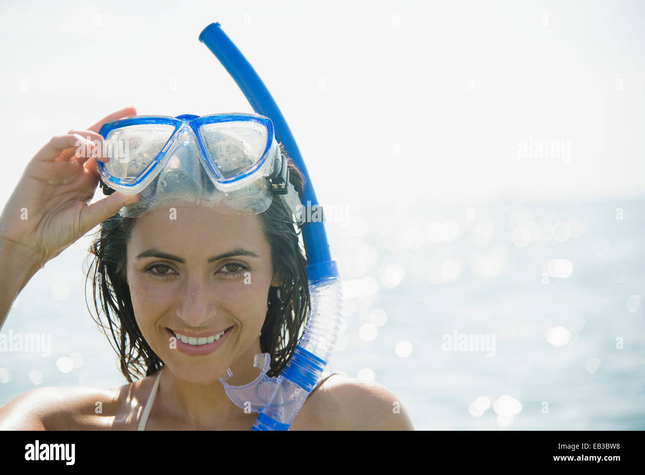 Caucasian donna che indossa lo snorkel e maschera in ocean Foto Stock