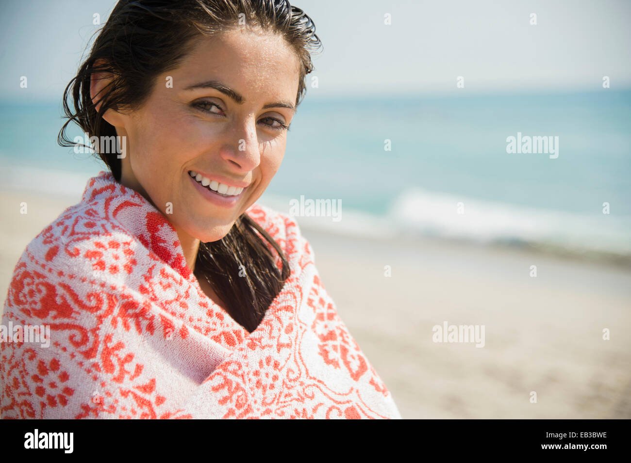 La donna caucasica avvolto in asciugamano sulla spiaggia Foto Stock