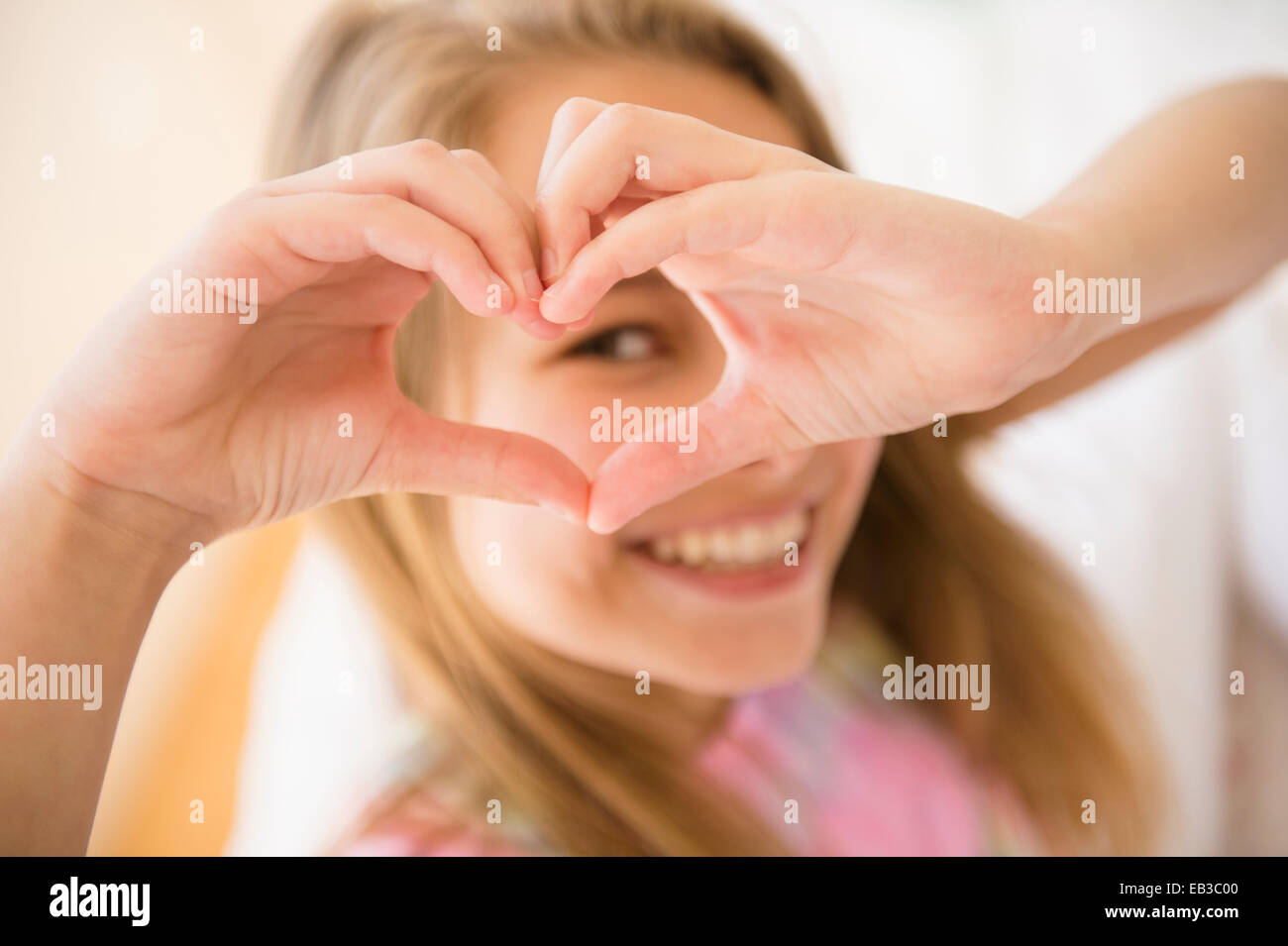 Ragazza caucasica messa a forma di cuore con le mani Foto Stock