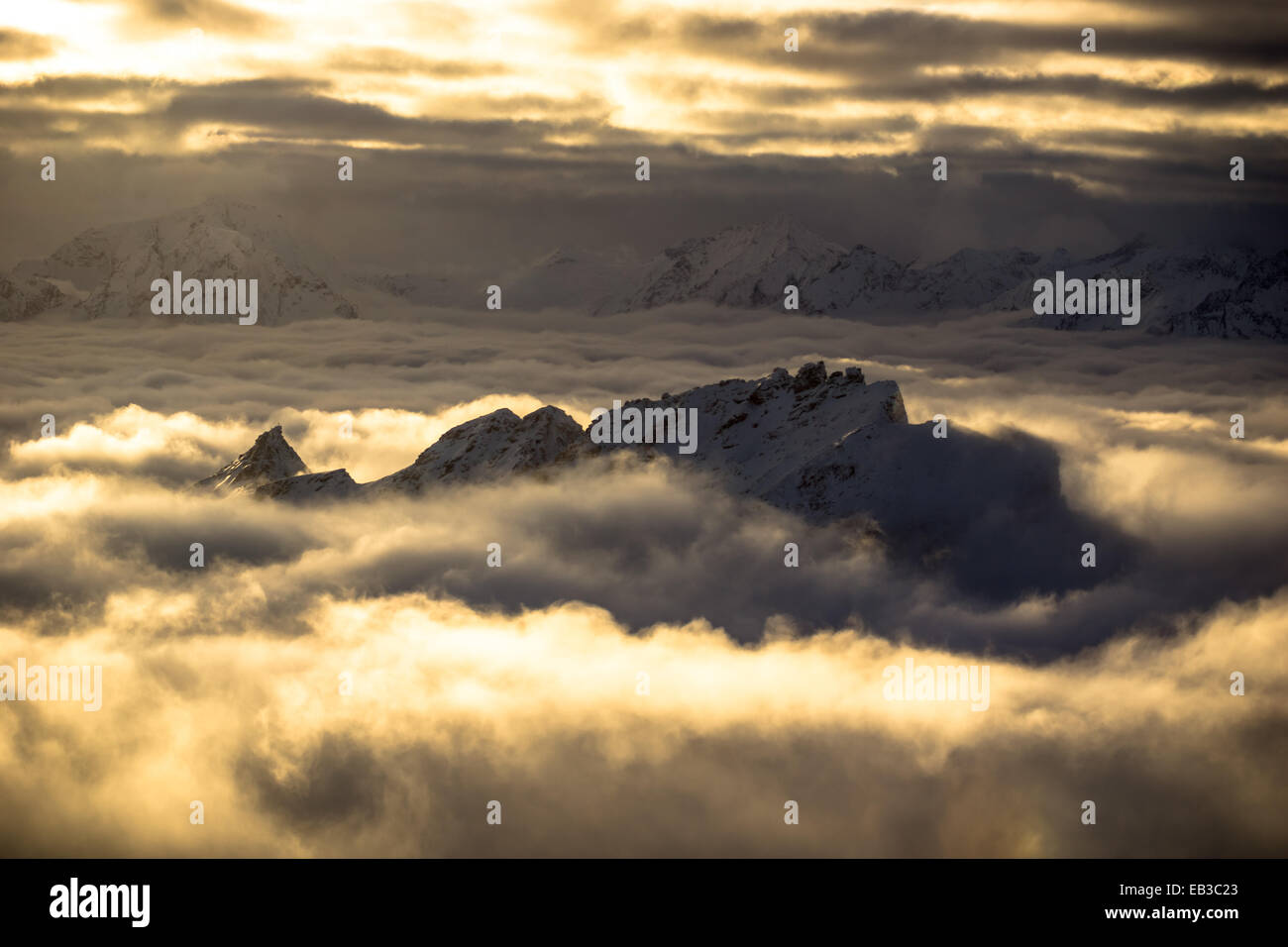 Vette di montagna attraverso il tappeto nuvoloso, Gastein, Austria Foto Stock