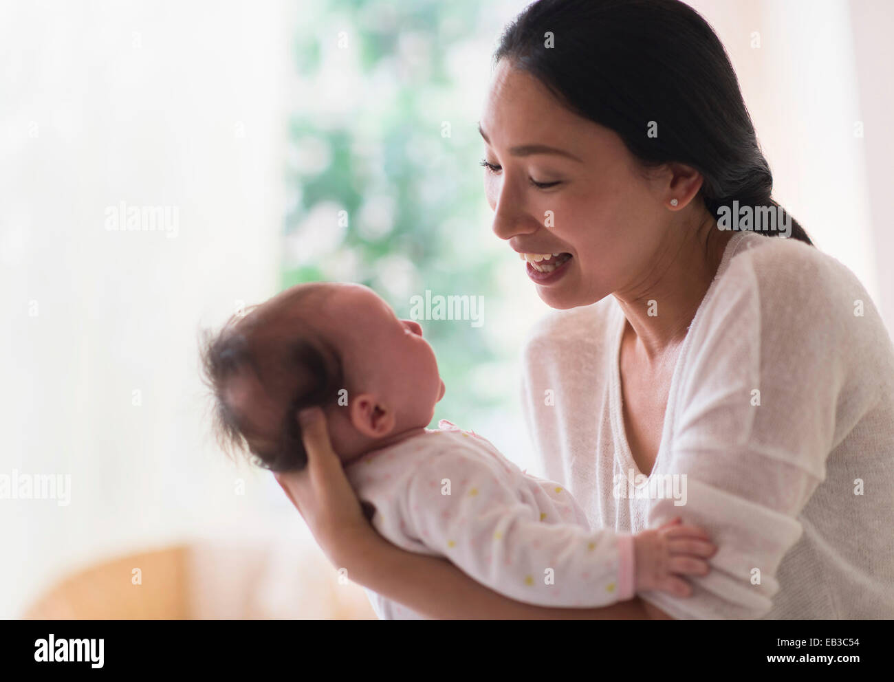 Asian madre holding baby Foto Stock
