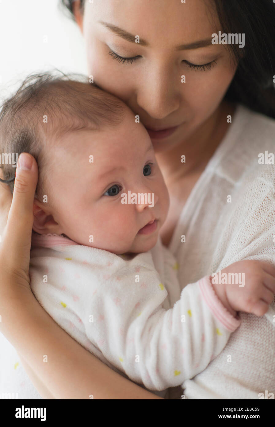 Asian madre holding baby Foto Stock