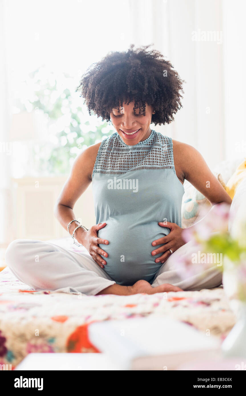 Africana incinta madre americana mentre tiene il suo stomaco Foto Stock