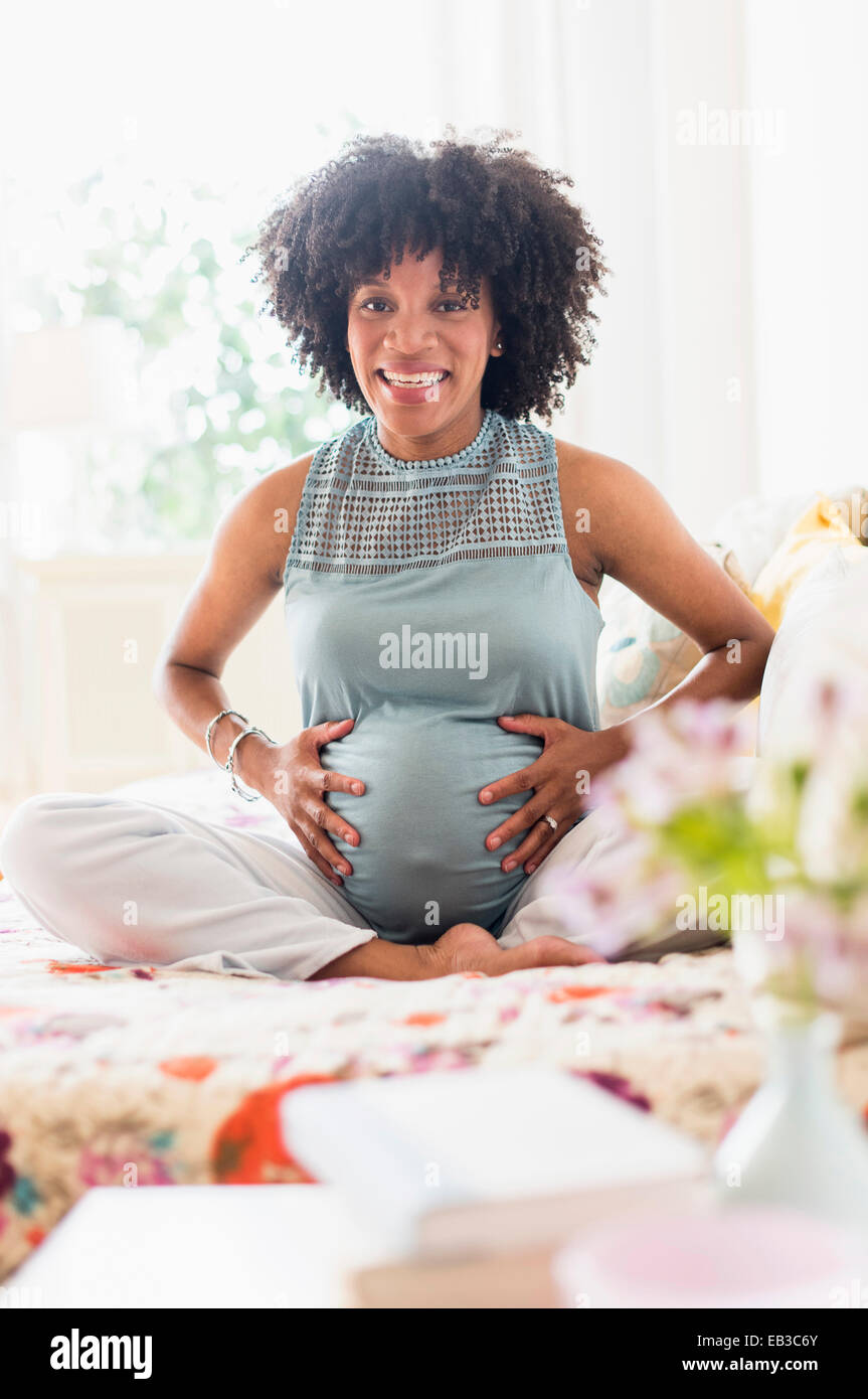 Africana incinta madre americana mentre tiene il suo stomaco Foto Stock