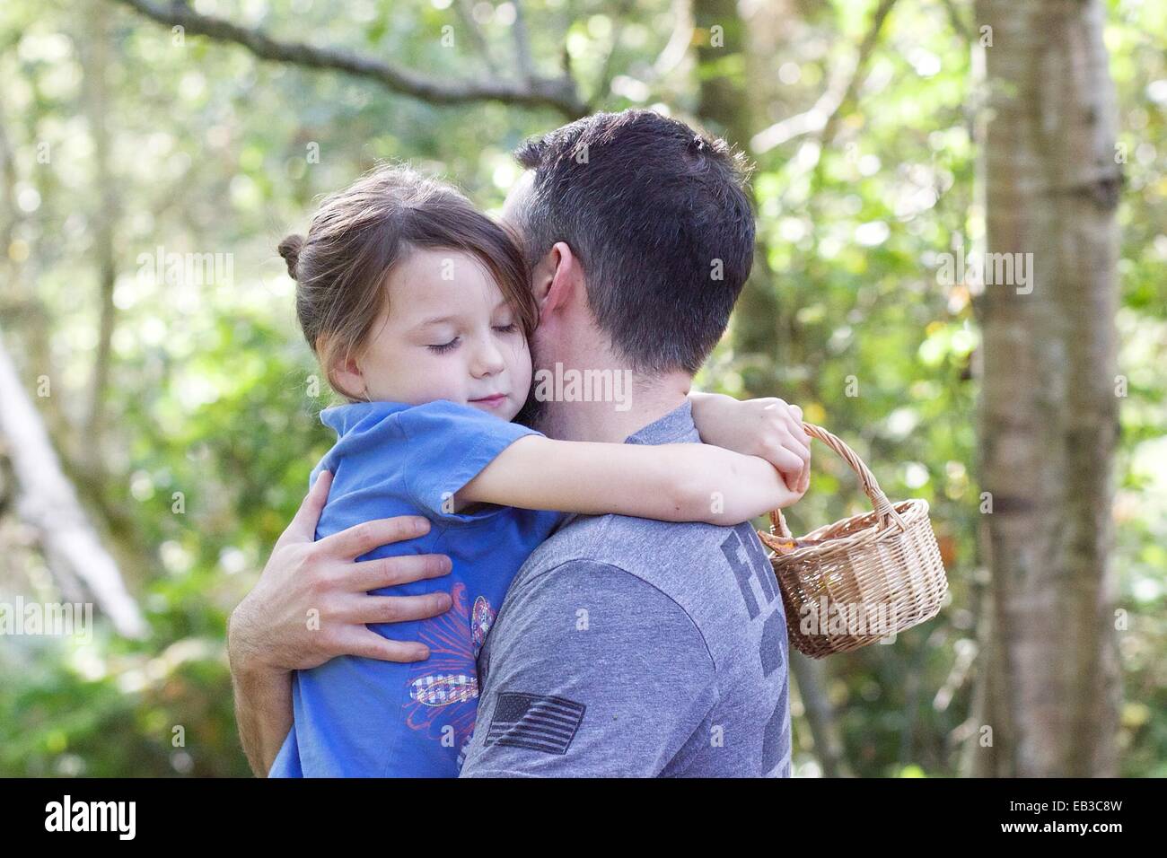 Ragazza in piedi nella foresta abbracciando il suo padre Foto Stock