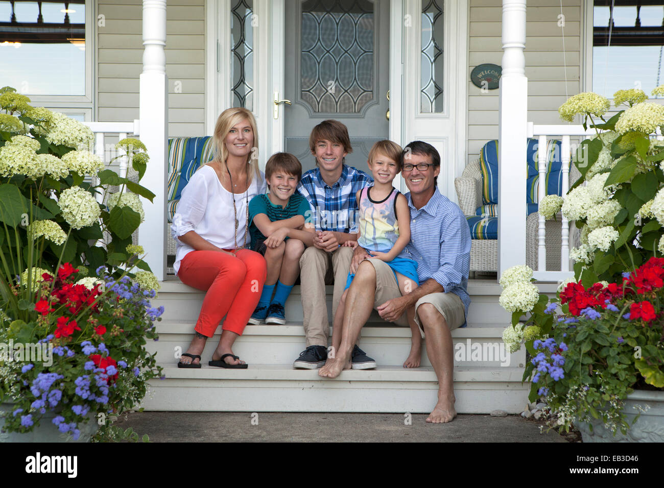 Famiglia caucasica sorridente sul portico anteriore Foto Stock