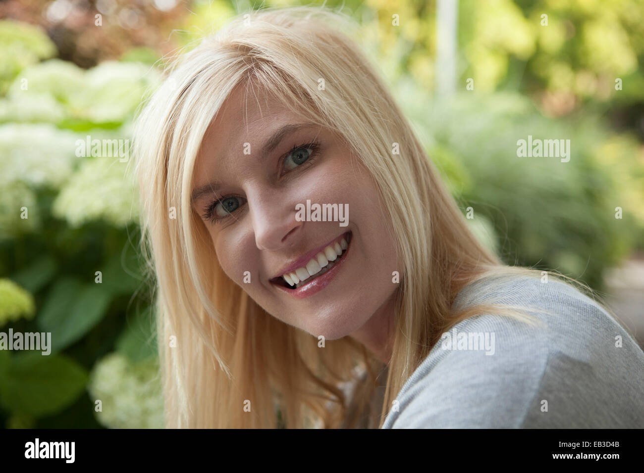 Sorridente Caucasian donna sorridente all'aperto Foto Stock