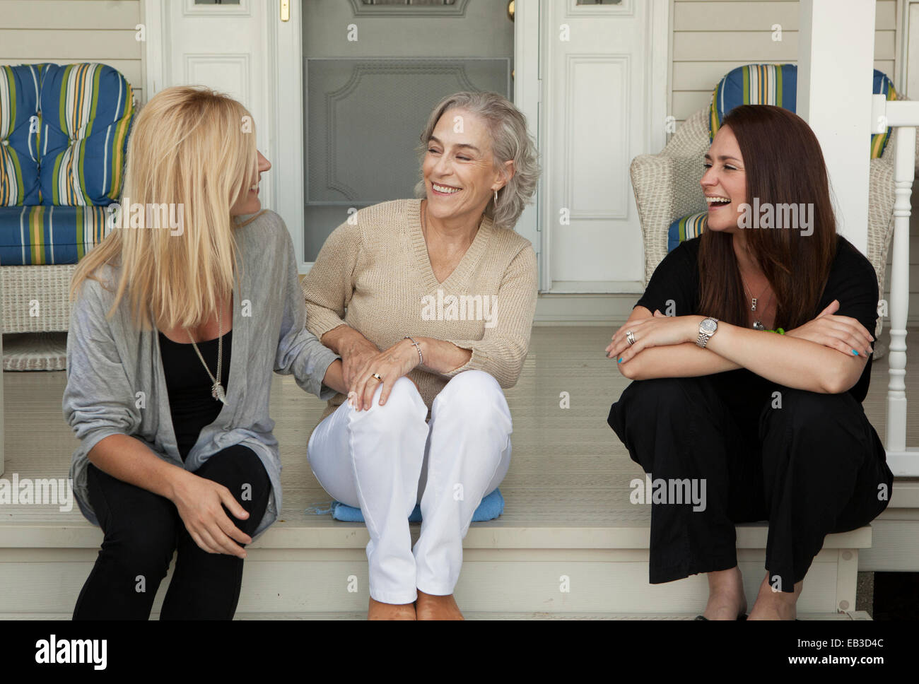 Caucasian la madre e le figlie sorridente sul portico anteriore Foto Stock
