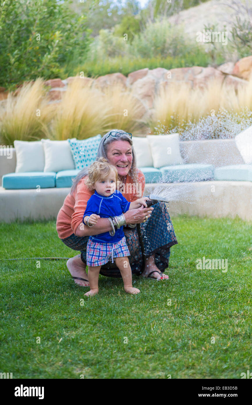 Nonna caucasica abbracciando baby nipote in cortile Foto Stock