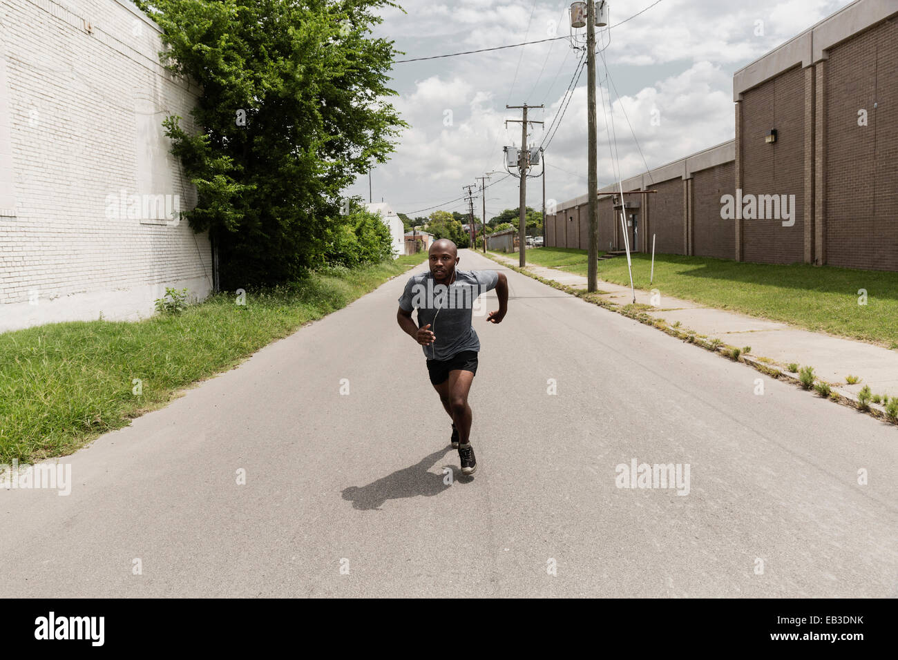 Uomo nero in esecuzione su una strada di città Foto Stock