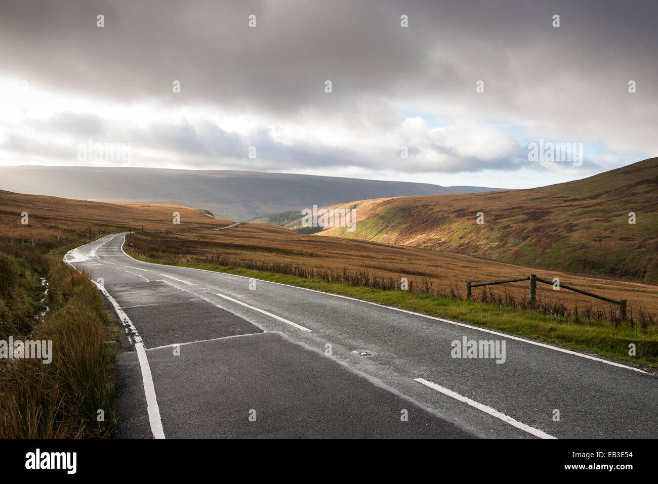 Un6024 Woodhead road. Cerca in discesa verso Woodhead con rottura sole attraverso il basso cloud. Foto Stock