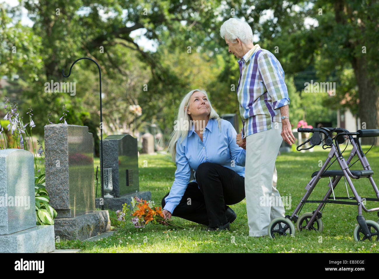 Caucasian madre e figlia visita tomba nel cimitero Foto Stock
