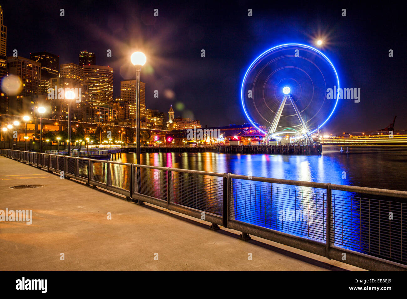 Illuminata ruota panoramica sul lungomare urbano di notte, Seattle, Washington, Stati Uniti Foto Stock