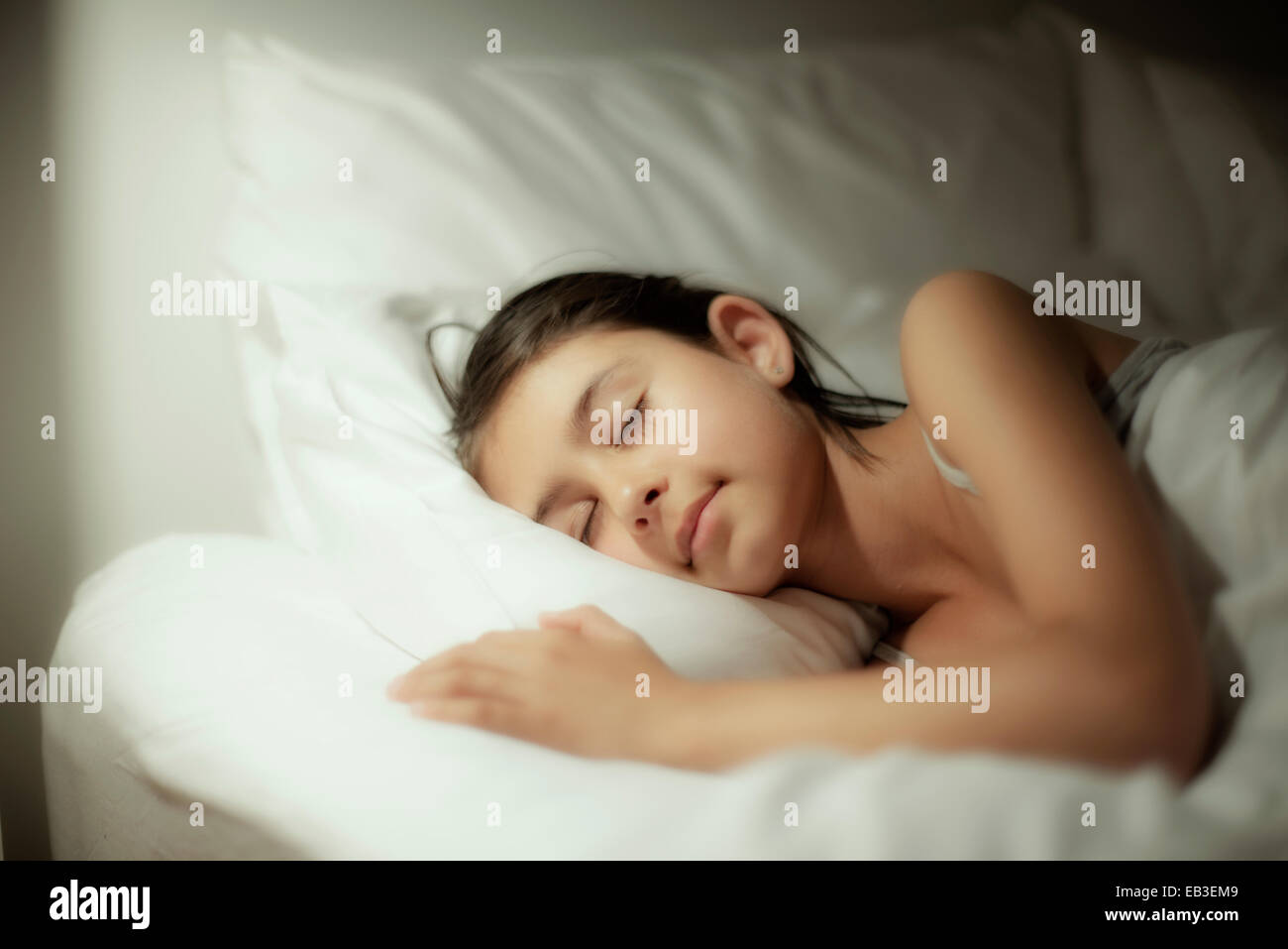 Razza mista ragazza dorme sul letto Foto Stock