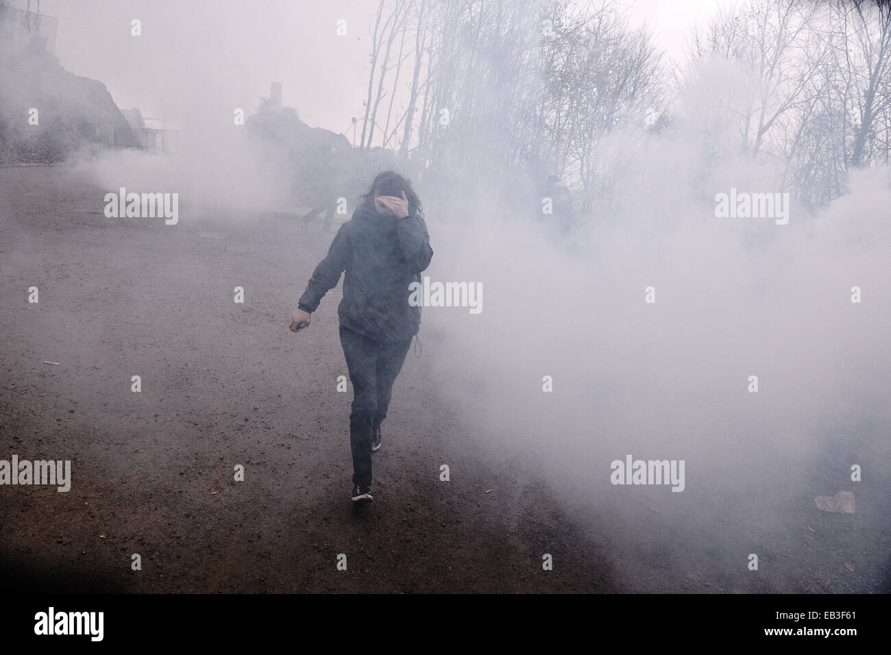 Un dimostrante viene eseguito dopo che un gas lacrimogeni attacco da parte della polizia durante una manifestazione contro il funzionamento delle miniere d'oro in Skouries, Calcidica, Grecia Foto Stock