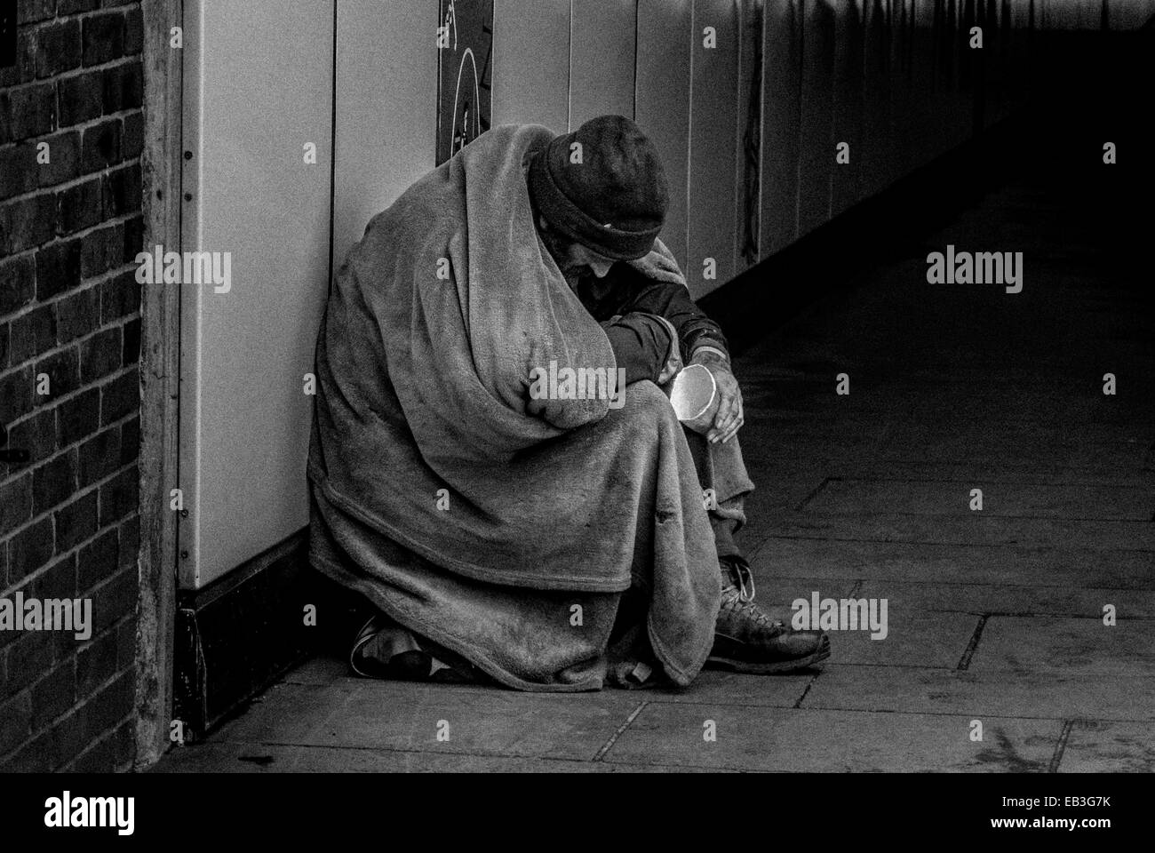 Senzatetto vagrant accattonaggio all'entrata di una metropolitana di Londra. Foto Stock