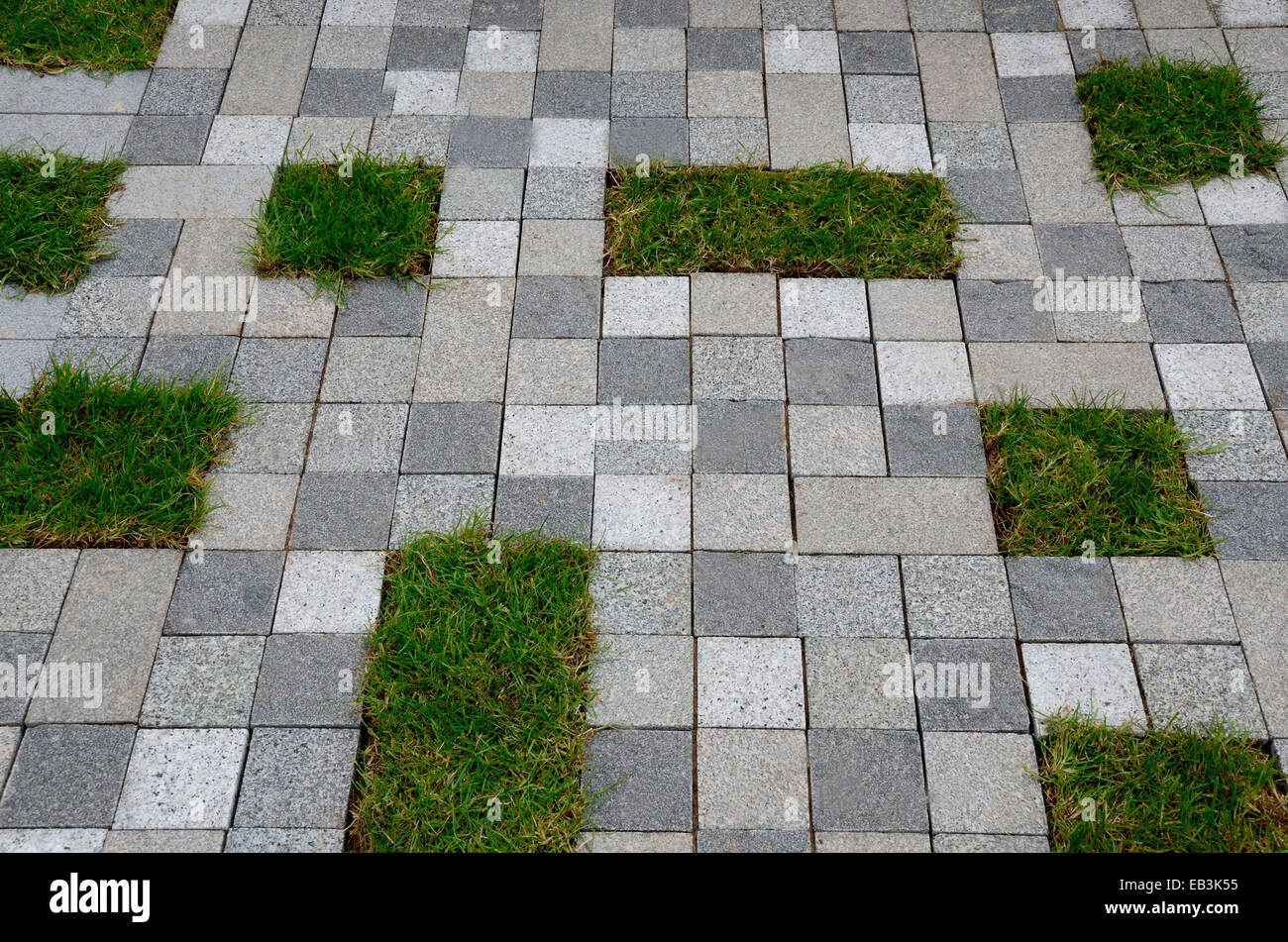 Un insolito lastricata di pietra in uno spazio pubblico urbano con piccola area di erba Foto Stock