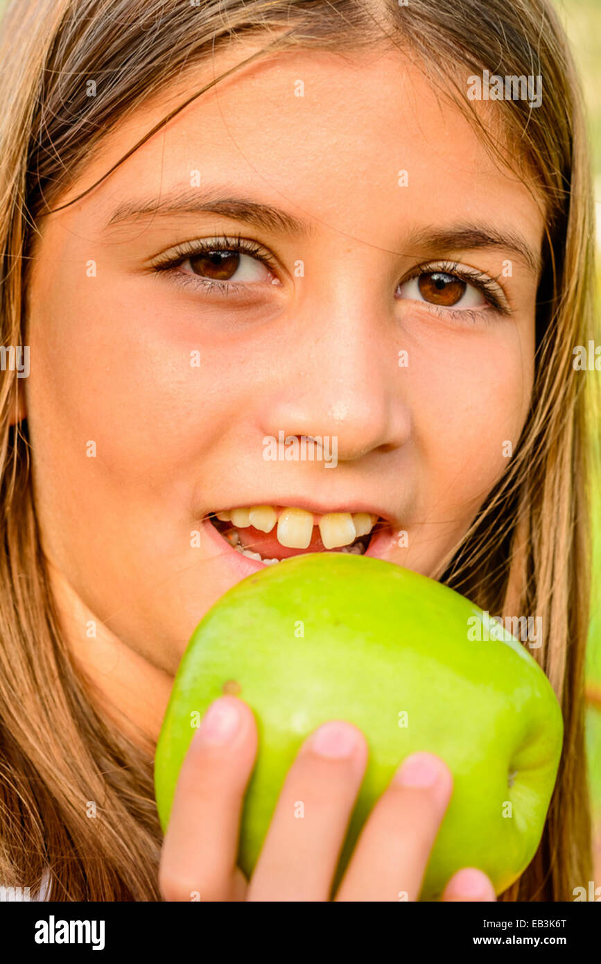 Bella 9 anno vecchia ragazza mangiare apple Foto Stock