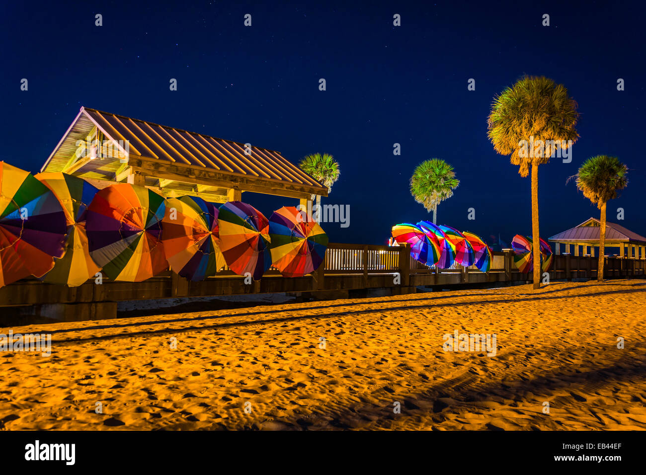 Palme e colorati ombrelloni da spiaggia di notte in Clearwater Beach, Florida. Foto Stock