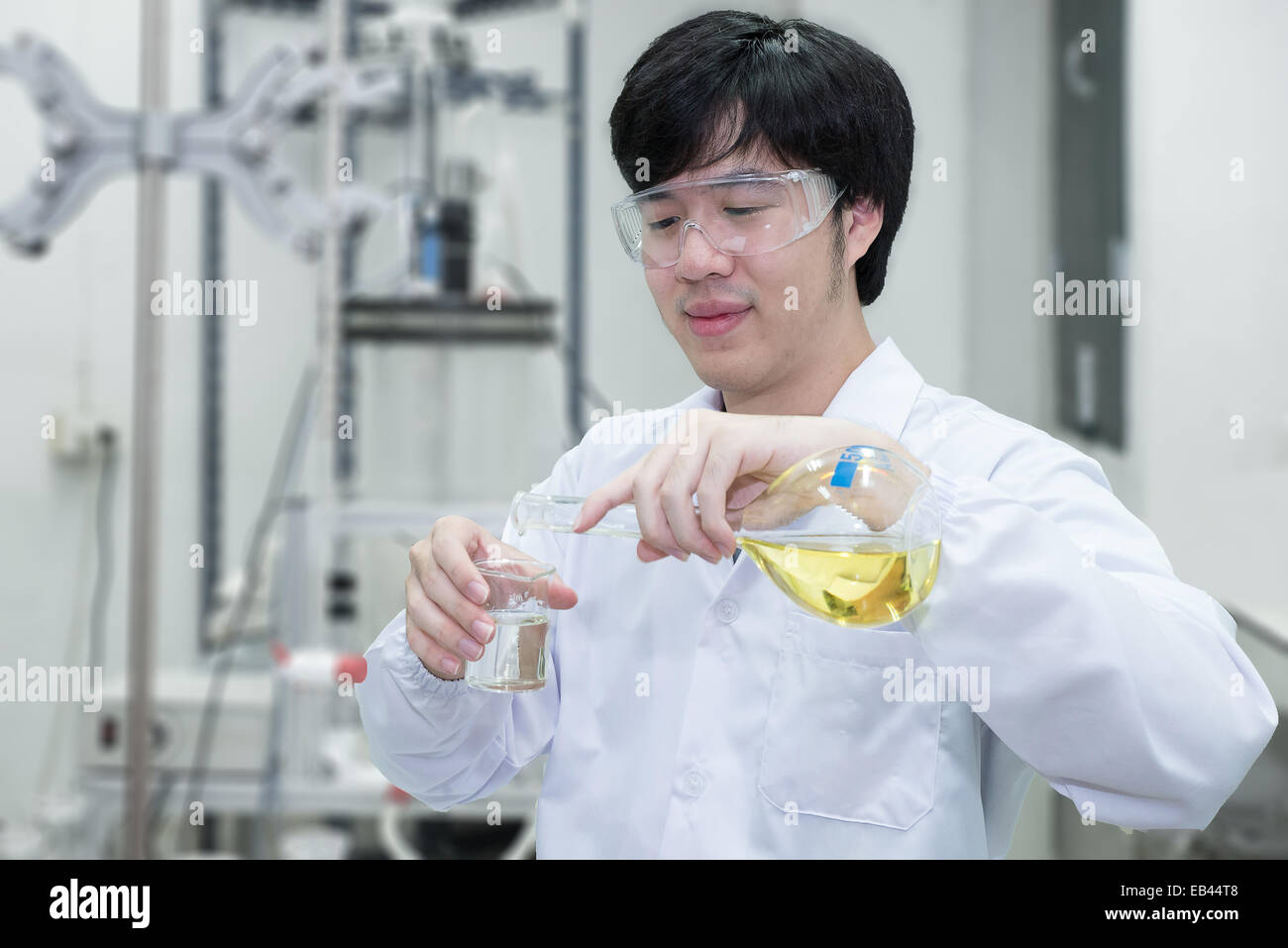 Scienziato il riempimento di una beuta in un laboratorio di chimica Foto Stock