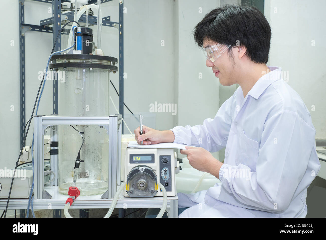 Scienziato conducendo ricerche prendendo appunti in laboratorio Foto Stock