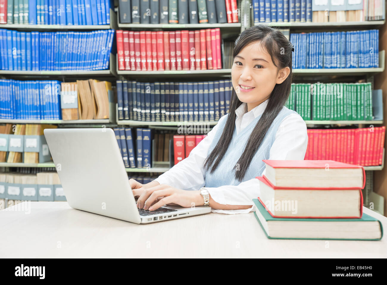 Asian studente utilizzando il computer portatile nella biblioteca universitaria Foto Stock