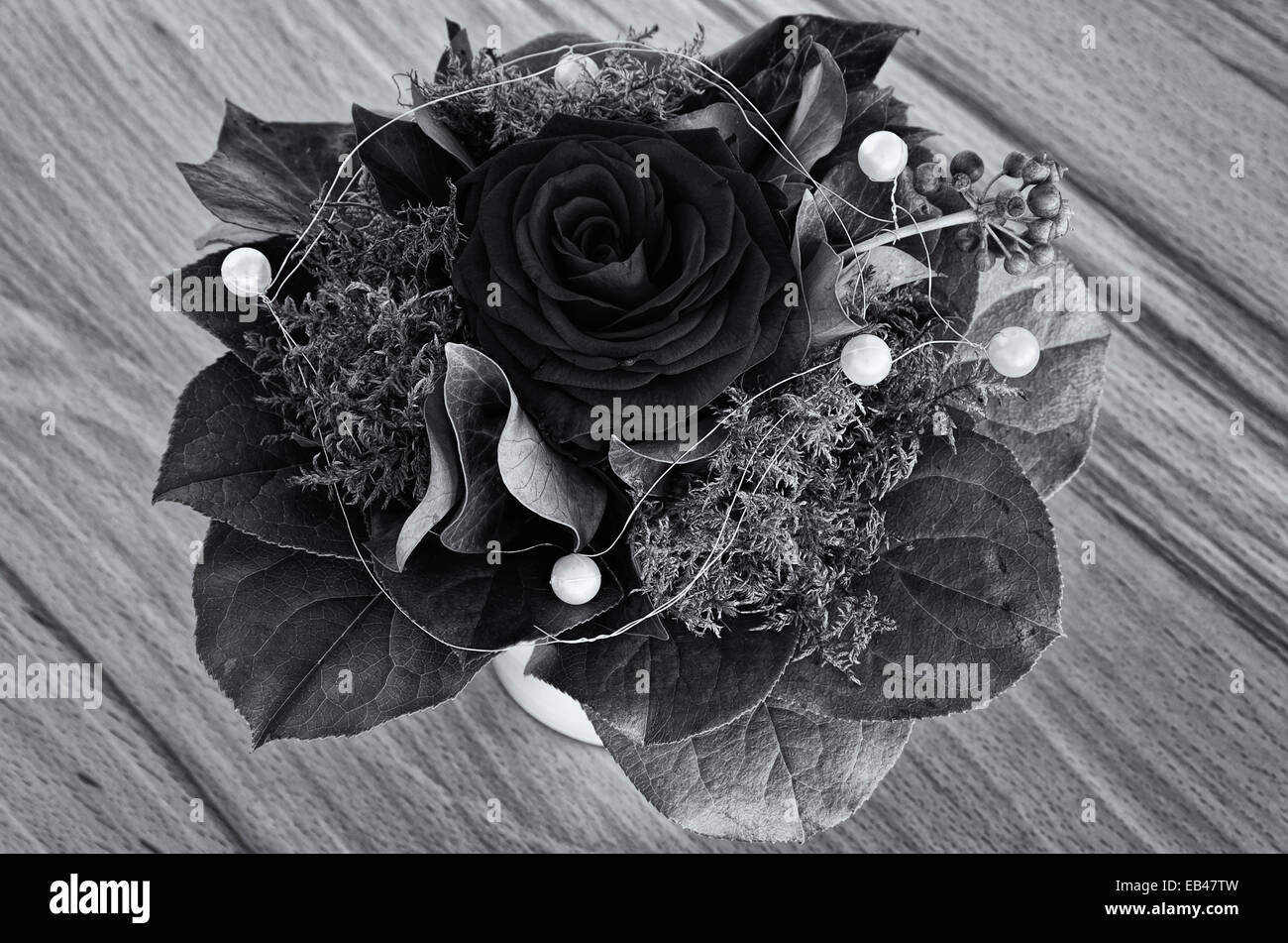 Single rose con verdi e perle di deco in un bouquet, in bianco e nero. Foto Stock