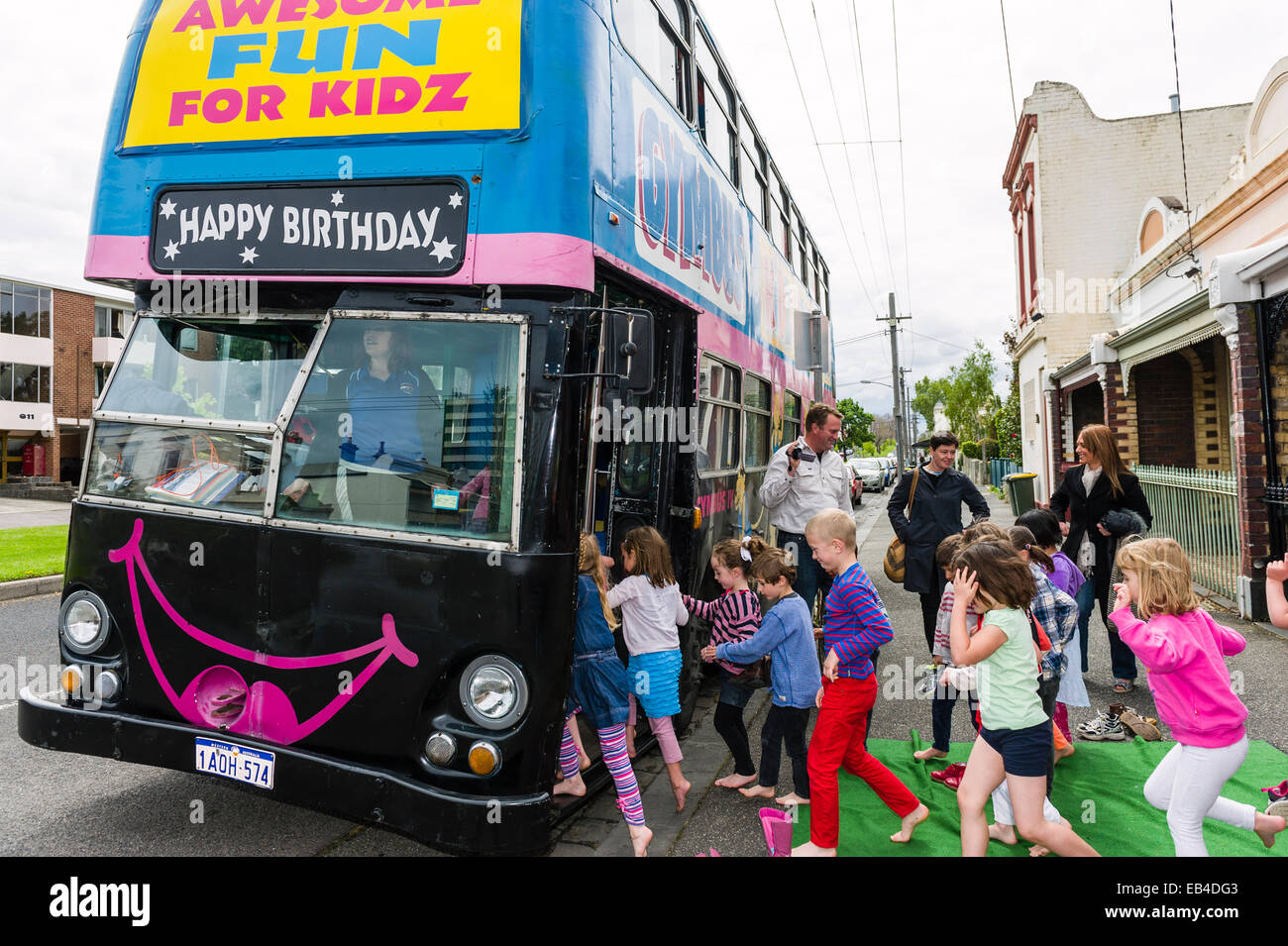 Bambini rush su un autobus a due piani trasformato in una festa di compleanno luogo per attività ginniche. Foto Stock