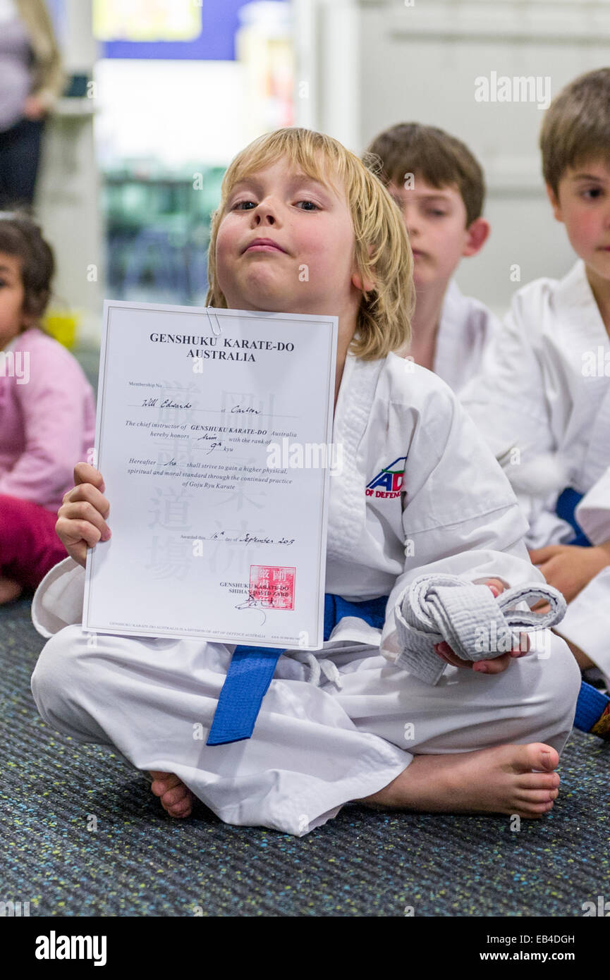 Un ragazzo visualizza il suo karate certificato rilasciato quando ha conquistato la sua cintura blu. Foto Stock