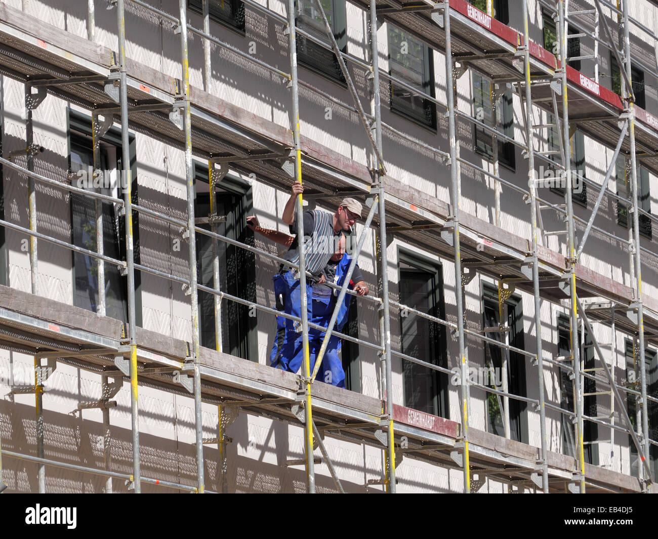 La costruzione dei lavoratori durante il lavoro in piedi sul metallo struttura di ponteggio Foto Stock