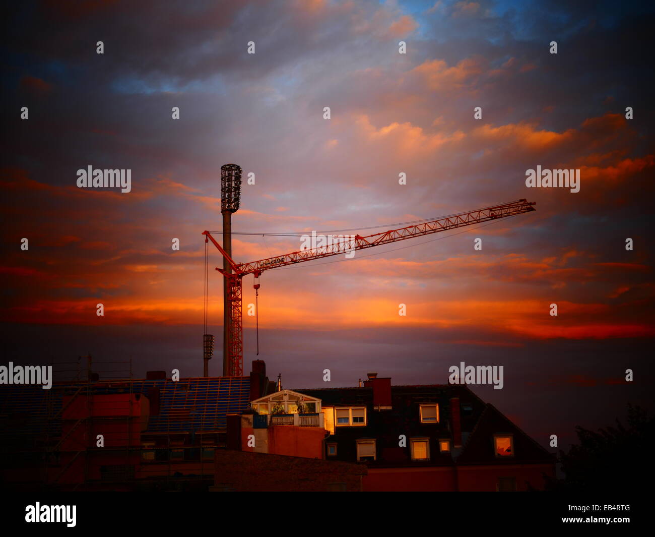 Gru da cantiere contro deep red sky Foto Stock