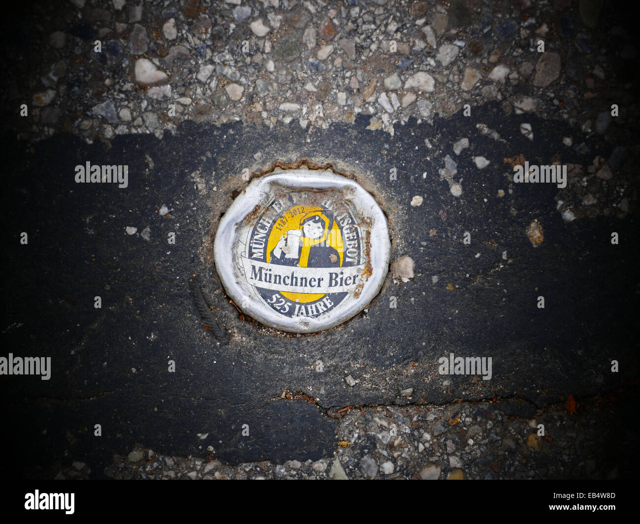 Soft drink tappi di metallo bloccato in asfalto stradale Foto Stock