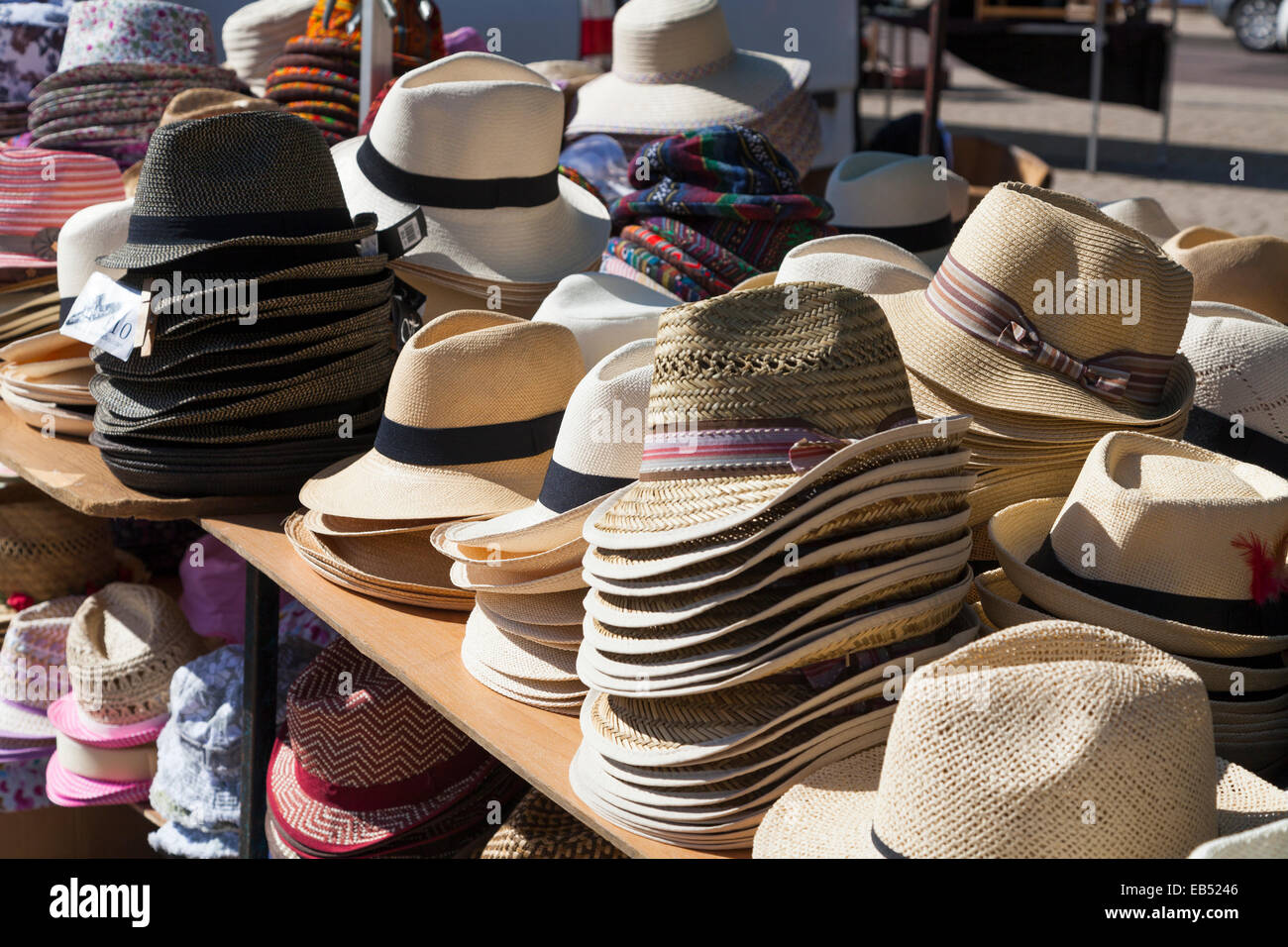 Pile di mens cappelli estivi per la vendita sul mercato in stallo Foto Stock