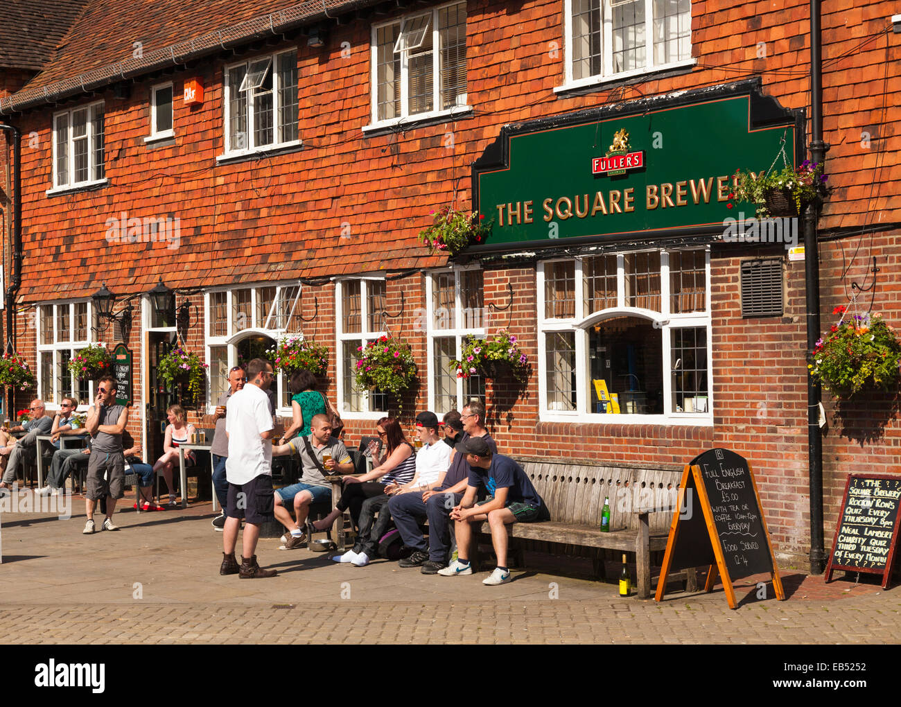 I bevitori sotto il sole al di fuori della Piazza pub birreria in Petersfield Foto Stock