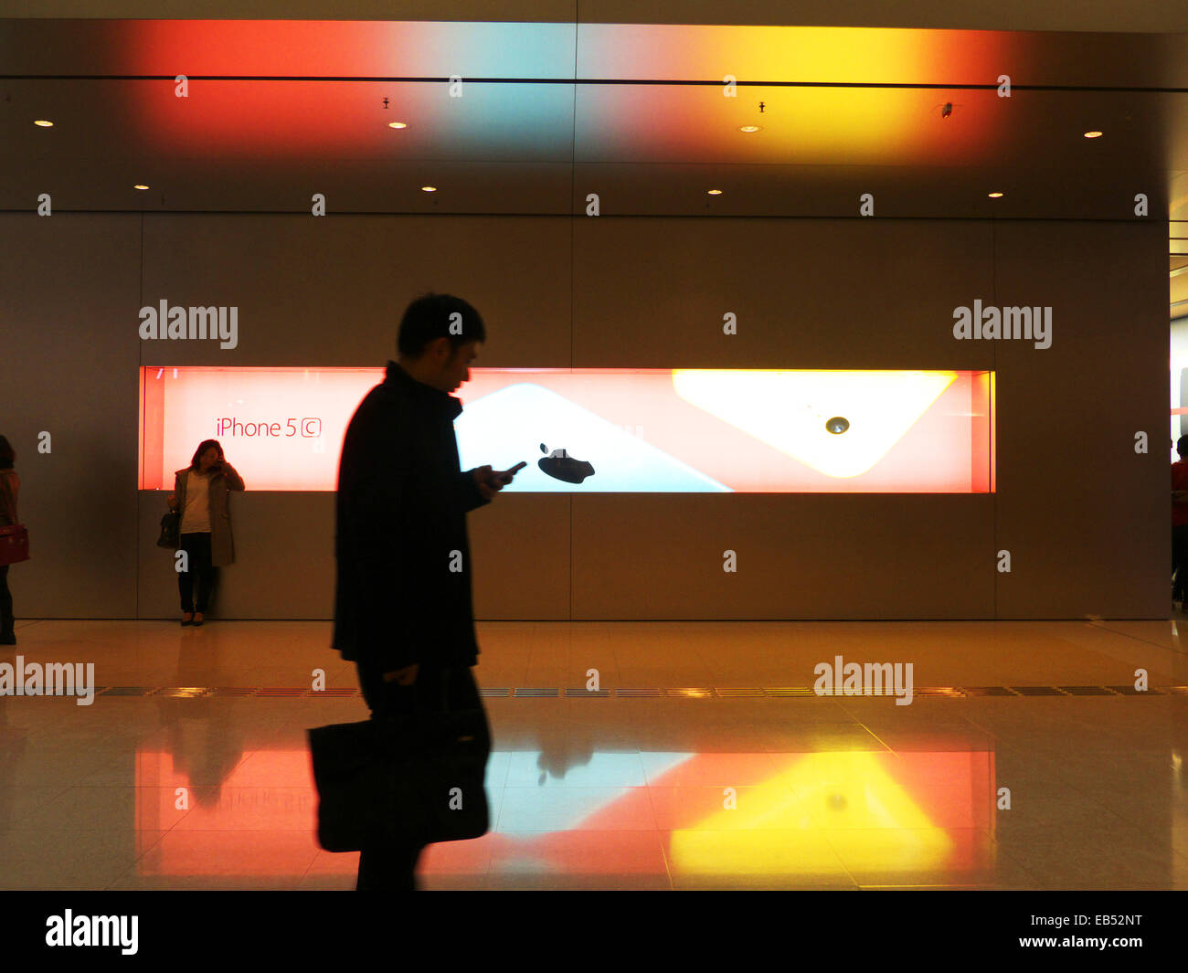 Cina pendolari passando iPhone 5C annuncio nella IFC Hong Kong Foto Stock