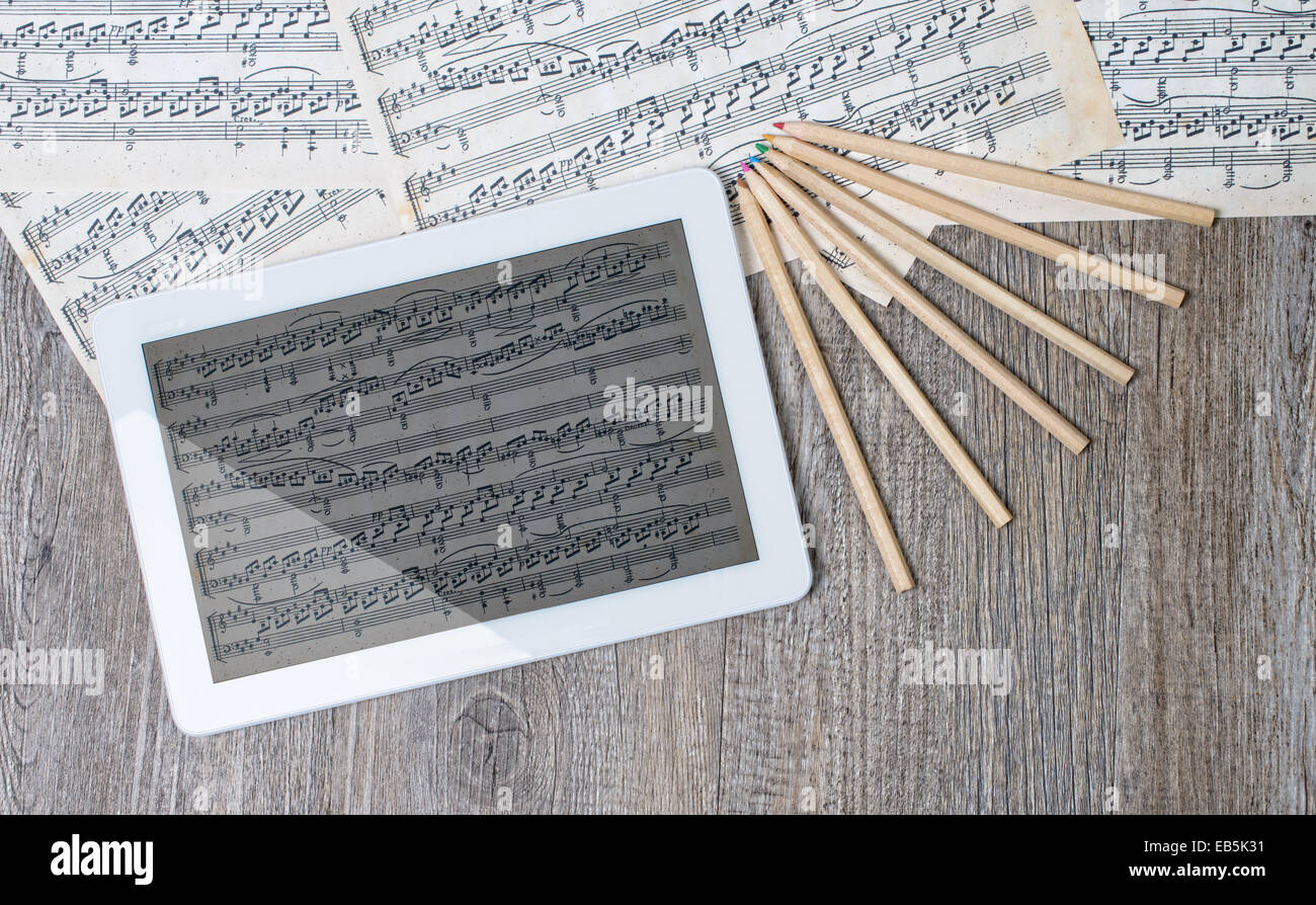 Spartiti musicali con una tavoletta digitale posto su un antico tavolo Foto Stock