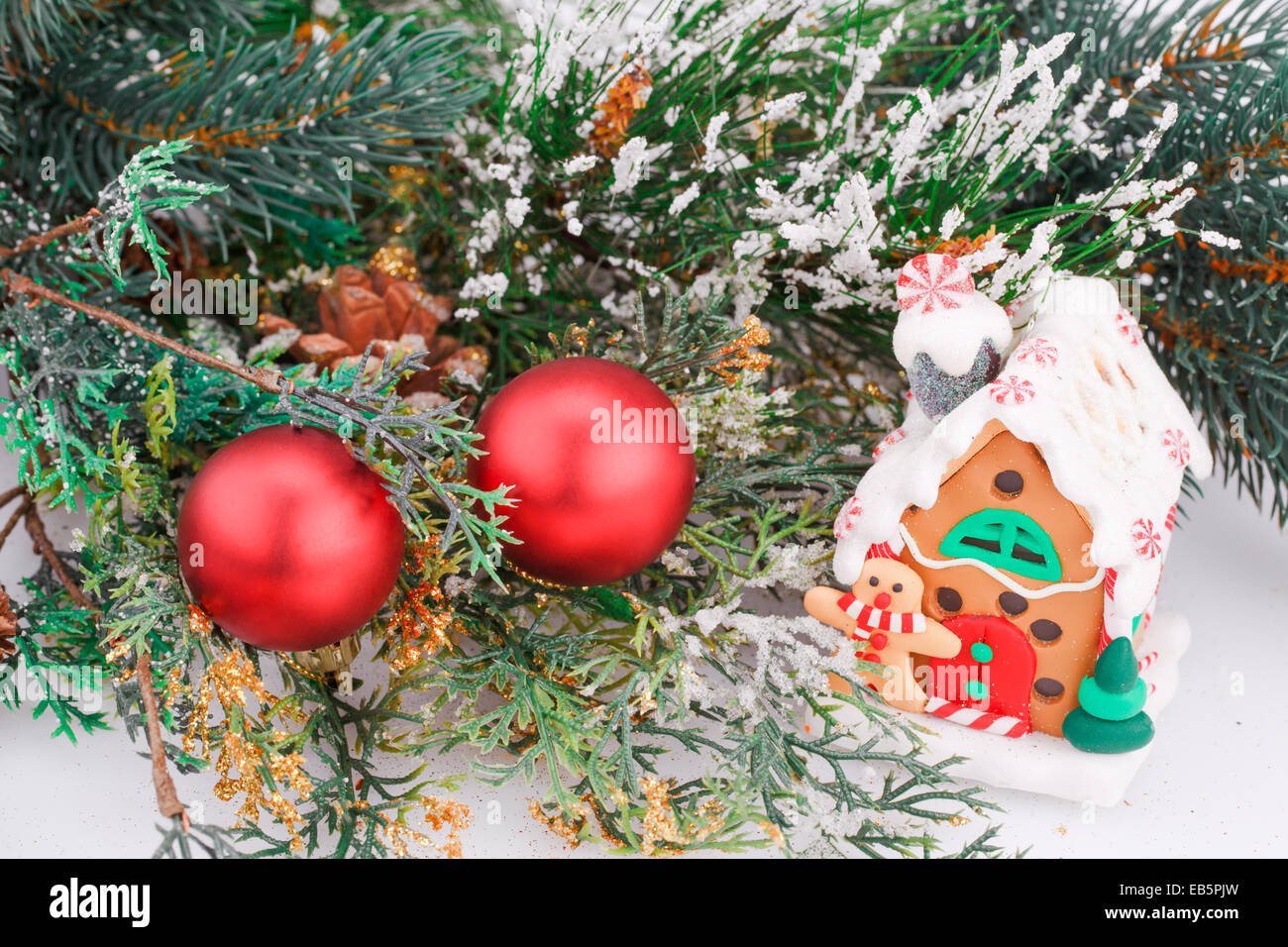 Decorazione di natale con palline rosse, fir-ramo di albero e casa del giocattolo. Foto Stock